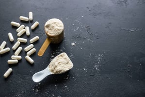 Supplement powders and pills on a black benchtop
