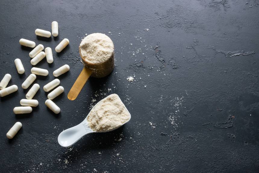 Supplement powders and pills on a black benchtop